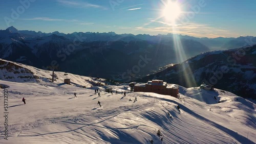 Leukerbad, Switzerland: Aerial time lapse of skiers and snowboarders going downhill on the slope of the Leukerbad ski resort in winter in the Swiss alps in Canton Valais. 