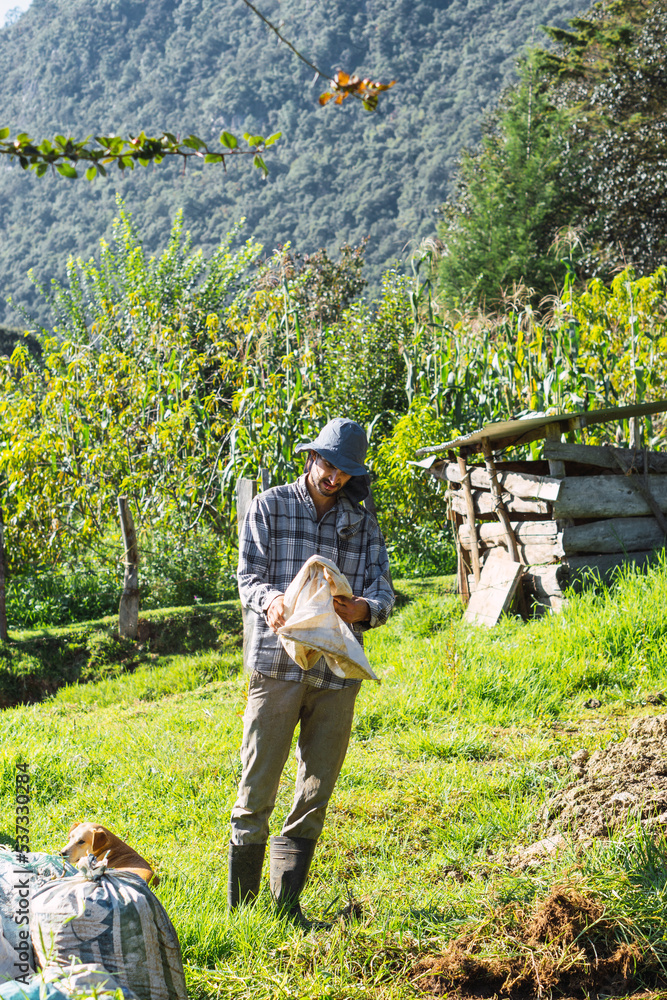 Naklejka premium Caucasian farmer standing with mountains in background.