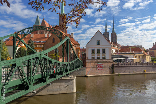 Fototapeta Naklejka Na Ścianę i Meble -  Wrocław, most Tumski  w tle zabytkowa część miasta. Pora roku jesień.