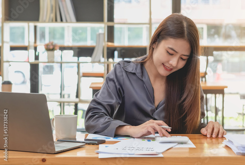 Marketing, Financial, Accounting, Planning, Team of business women analyze company results and profits with graph statistics. Use a laptop computer and a calculator to calculate the company's balance.