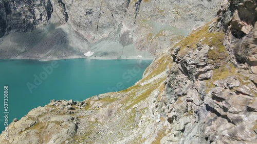 Aerial drone flight over artificial turquoise lake in the rocky mountains. Clear water with reflections. Lago della Rossa, Usseglio (Italy) photo