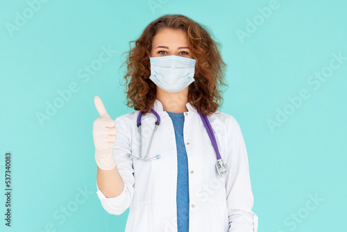 Covid19, coronavirus, healthcare and doctors concept. Portrait of optimistic caucasian female doctor assure everything be okay, thumb-up, wear medical mask to prevent catching virus, white coat