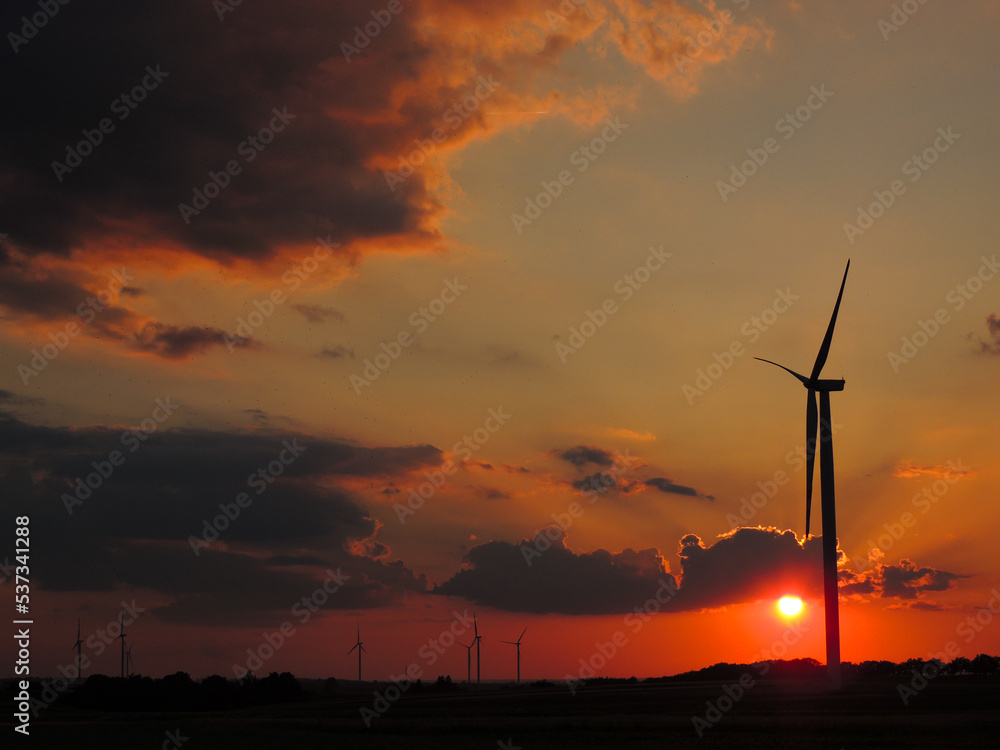 wind power plant, windmills on the background of the word sunset, in the village of Gać