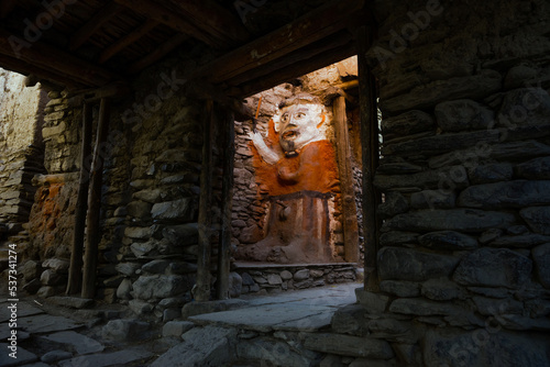 Male totem at the narrow dark Kagbeni village street. Mustang, Nepal, Annapurna circuit trek / Jomsom trek. photo