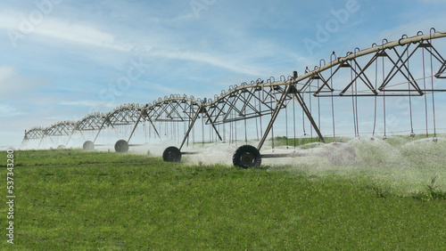 Grass field irrigated by a pivot sprinkler system i photo