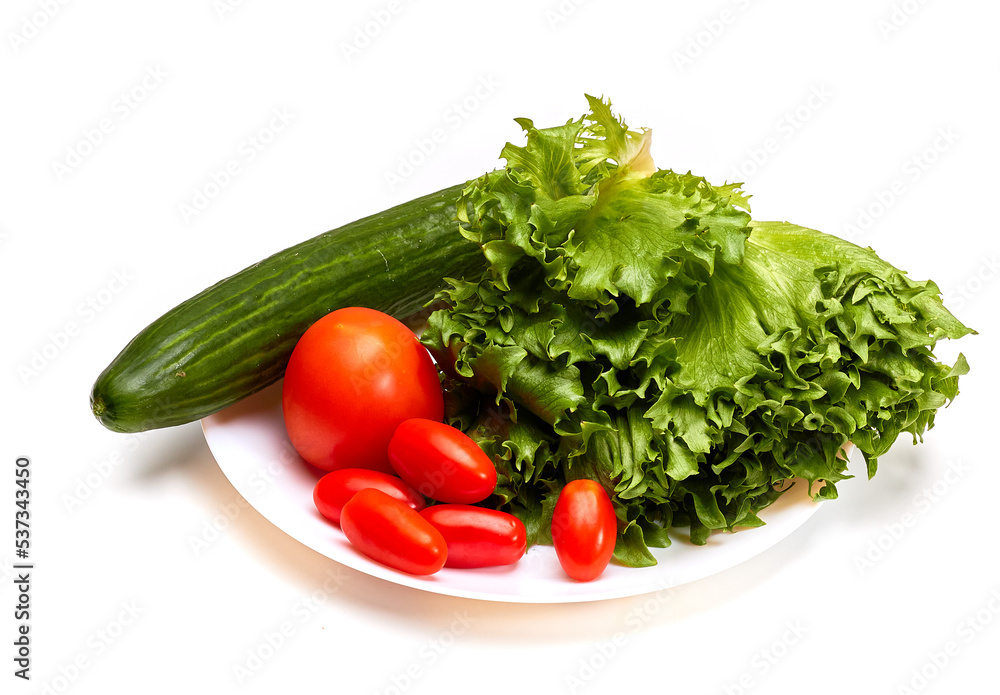 Fresh tomatoes, cucumber and lettuce on a white plate. Isolated. Fresh tomatoes, cucumber and lettuce on a white plate. Isolated.