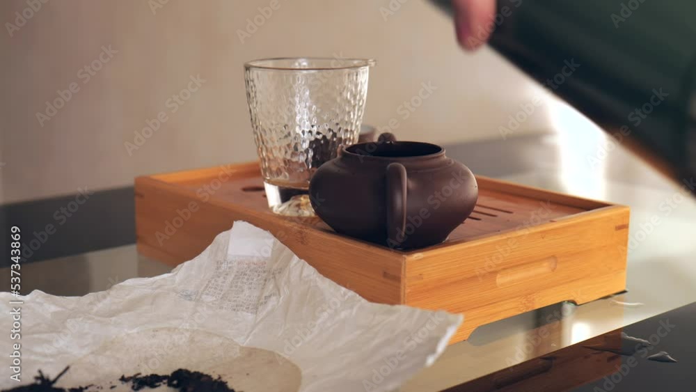 Tea ceremony, boiling water is poured into a clay teapot for brewing