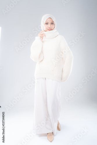 Full length portrait of a beautiful Muslim female model wearing modern and stylish casualwear with hijab isolated white studio background. Modern hijab fashion and beauty concept