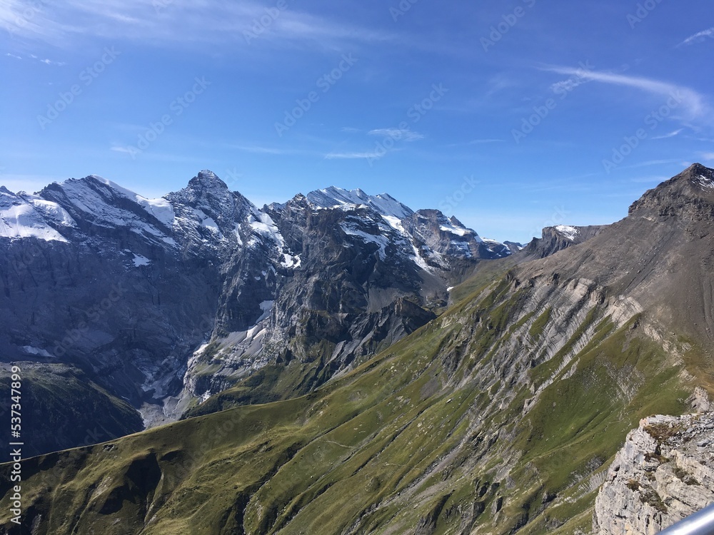 Huge mountains landscape view. Mountains in the summer sunny day in the Switzerland. Nature landscape with mountains, forest and green fields. Travel to Switzerland and mountain landscape. 