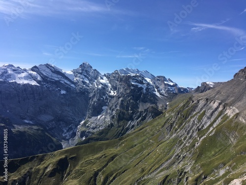 Huge mountains landscape view. Mountains in the summer sunny day in the Switzerland. Nature landscape with mountains, forest and green fields. Travel to Switzerland and mountain landscape. 
