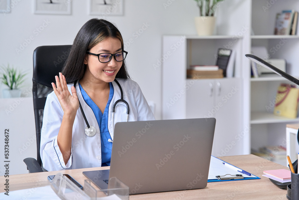 Young Asian female doctor greeting patient during video conference call Young Asian female doctor greeting patient during video conference call