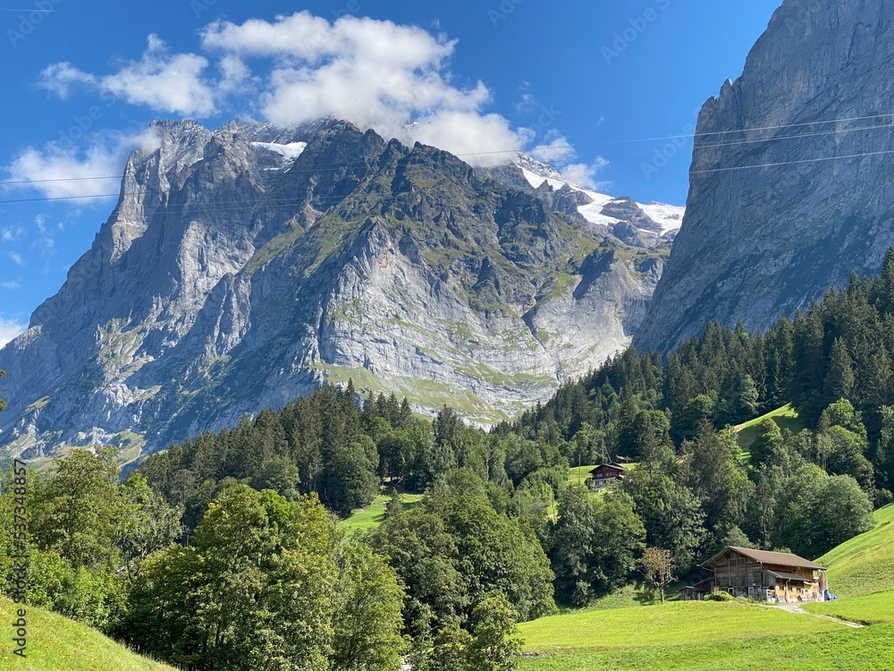 Mountains landscape on the summer day with blue sky. Switzerland mountain with rocks, trees and forest. Nature landscape view with mountains and lake. Lake in the mountains. 
