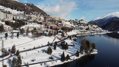 St Moritz, Switzerland: Aerial drone footage of the Saint Moritz ski resort village and lake on a sunny winter day in the Engadine valley in Canton Graubunden in the Swiss alps.  photo