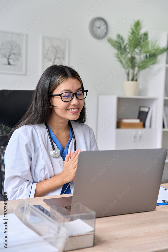 Happy young Asian woman doctor having online video conference with patient Happy young Asian woman doctor having online video conference with patient