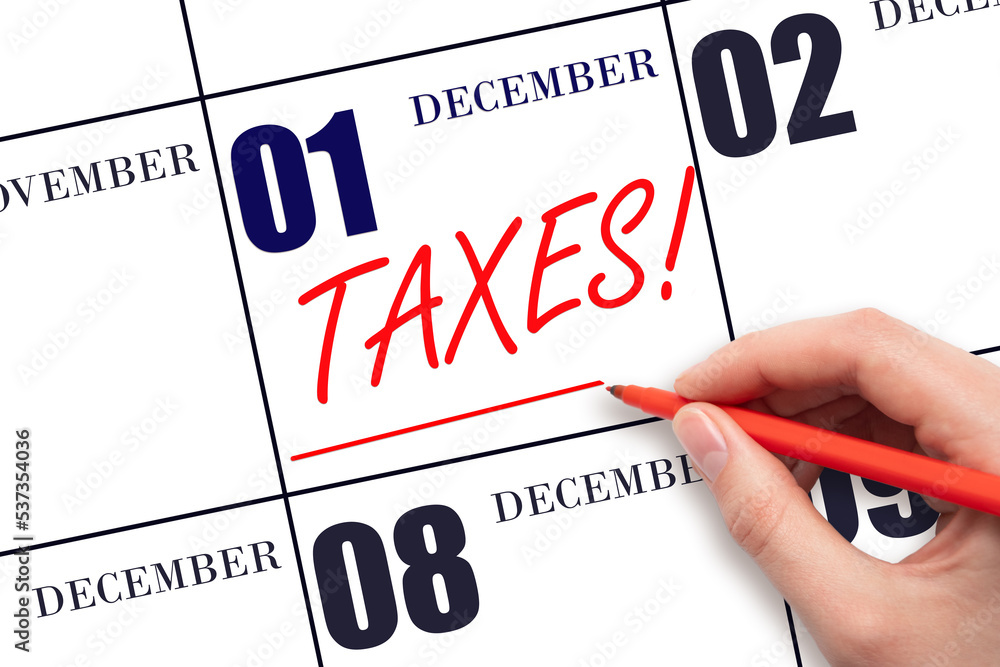 Hand drawing red line and writing the text Taxes on calendar date December 1. Remind date of tax payment Hand drawing red line and writing the text Taxes on calendar date December 1. Remind date of tax payment