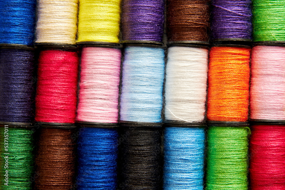 Background pattern of set of colorful rainbow sew thread spools on the wooden tailor table. Embroidery background Background pattern of set of colorful rainbow sew thread spools on the wooden tailor table. Embroidery background