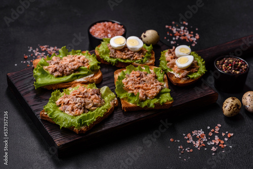Delicious fresh sandwiches with toast, canned salmon, salad and quail eggs
