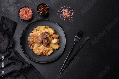 Delicious vegetable stew with beef, potatoes, carrots and cabbage in a black plate