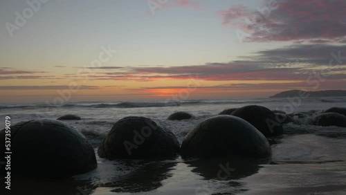 Sunrise on the Moeraki Boulders on the beach, in New Zealand