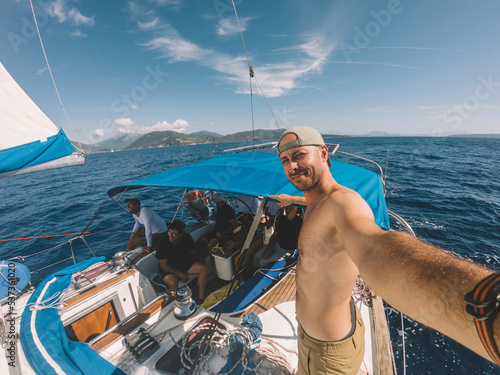 Man taking selfie with sailboat crew