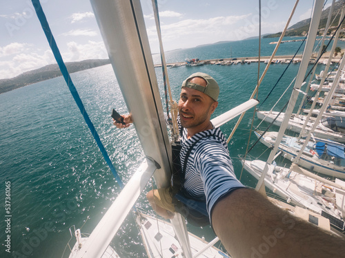 Man in sailor shirt taking selfie from sailing boat must