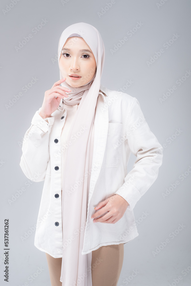 Half length portrait of a beautiful Muslim female model wearing modern and stylish casualwear with hijab isolated white studio background. Modern hijab fashion and beauty concept Half length portrait of a beautiful Muslim female model wearing modern and stylish casualwear with hijab isolated white studio background. Modern hijab fashion and beauty concept