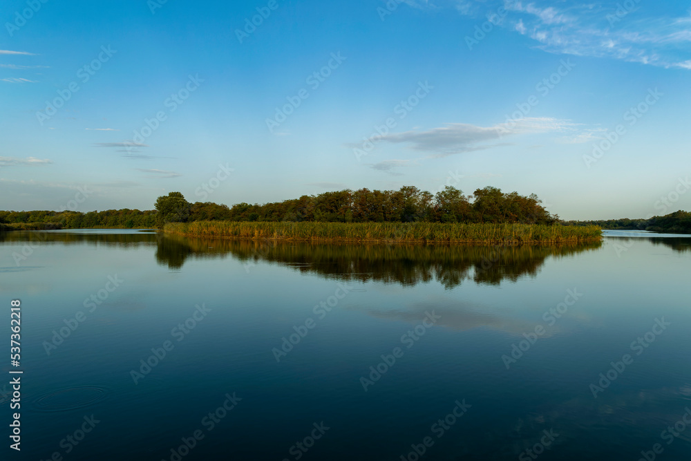 Sunny spring morning on the river bank. Picturesque rural landscape. Summer sunny background.