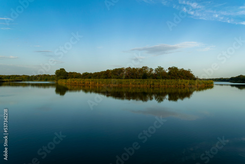 Sunny spring morning on the river bank. Picturesque rural landscape. Summer sunny background.