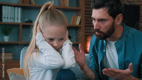Sad offended little child daughter feel stress cover ears ignoring scream caucasian angry annoyed man dad shouting on girl for bad behavior and disobedience scolding kid problem of parenting in family