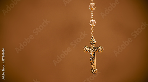 detail of a crucifix, colored background, christian symbol, with copyspace, catholic religious theme background © RHJ