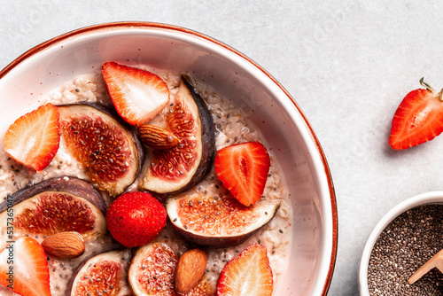 Delicious oatmeal with fig pieces  strawberries and chia seeds on a light background. superfood concept. Healthy  clean eating. Vegan or gluten free diet