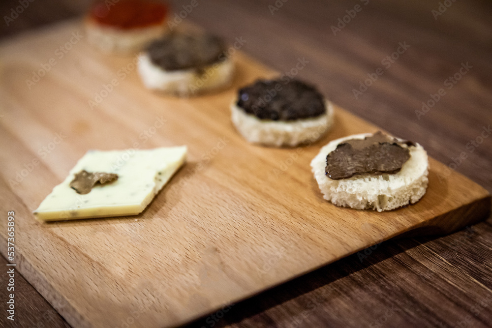 Table decoration with white and black Truffles and white wine. Black and white Truffles on a wooden table.
Table decoration with white and black Truffles and white wine. Black and white Truffles on a wooden table.
