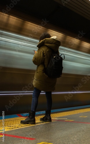 Vertical long exposure shot of a woman waiting at  atrain station photo