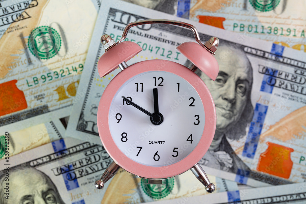 pink quartz alarm clock isolated on 100 dollar backgrounde pink quartz alarm clock isolated on 100 dollar backgrounde