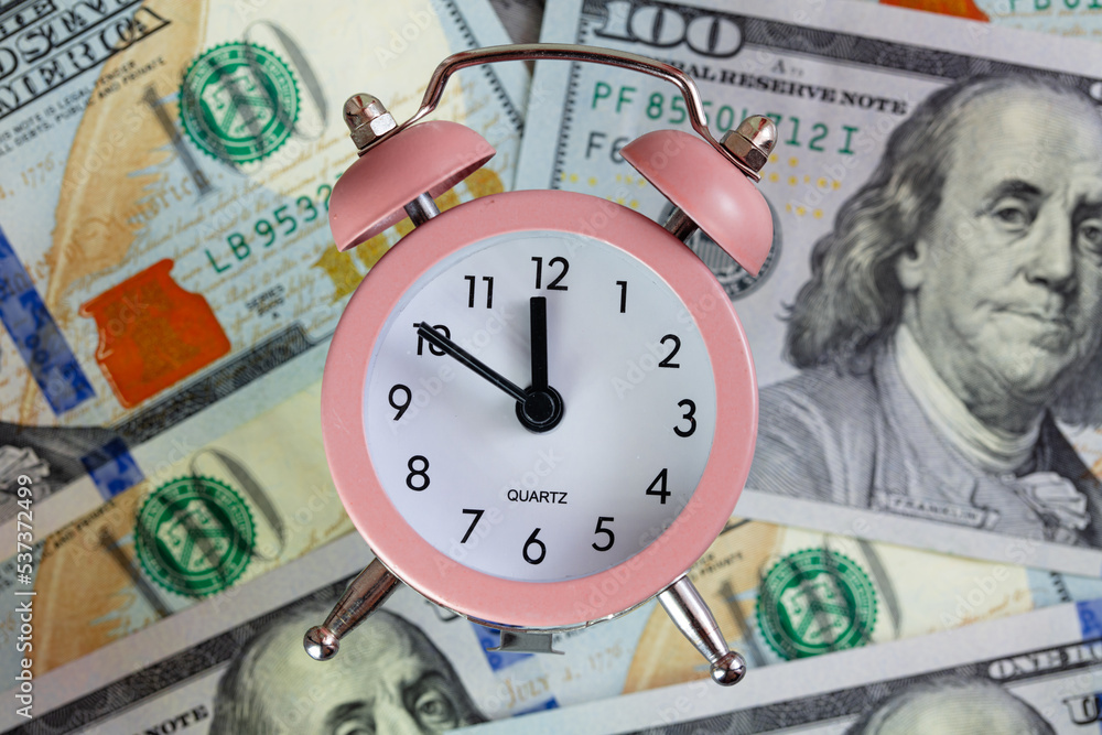 pink quartz alarm clock isolated on 100 dollar backgrounde pink quartz alarm clock isolated on 100 dollar backgrounde