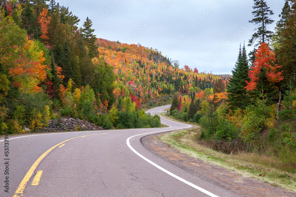 Curving road and colorful trees on hills near Caribou Lake in northern Minnesota during autumn Curving road and colorful trees on hills near Caribou Lake in northern Minnesota during autumn