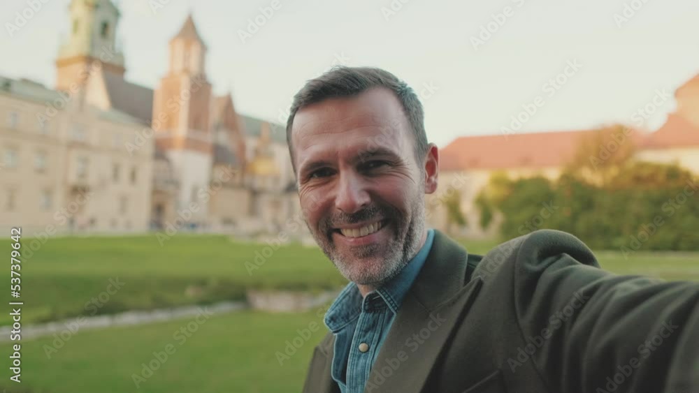 Man takes selfie on mobile phone on the old city background Man takes selfie on mobile phone on the old city background