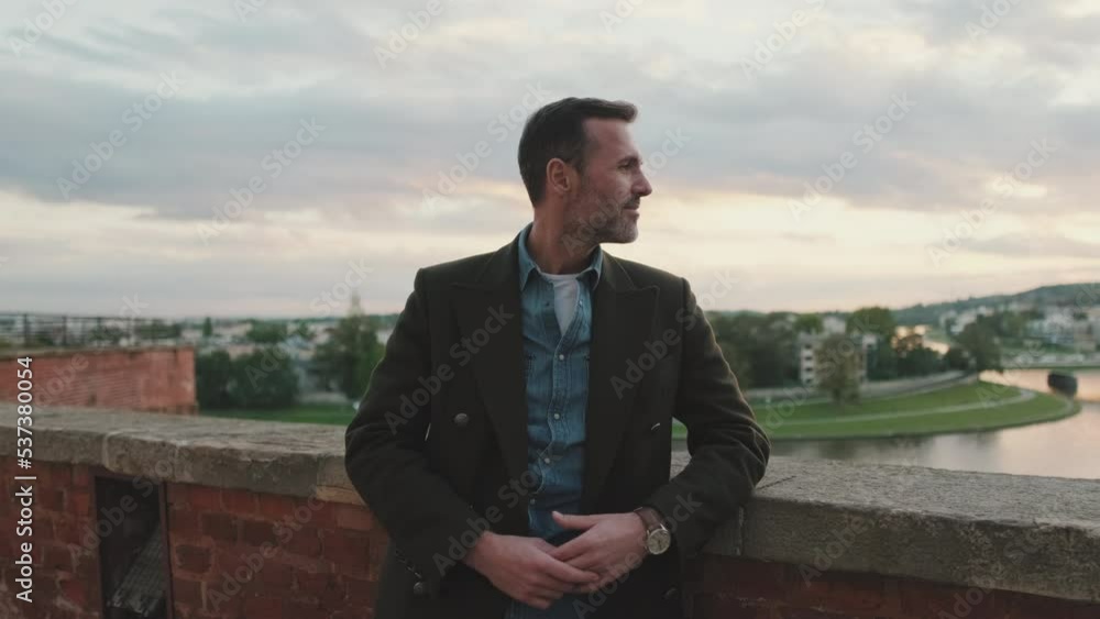 Man looks around standing against the background of the river Man looks around standing against the background of the river