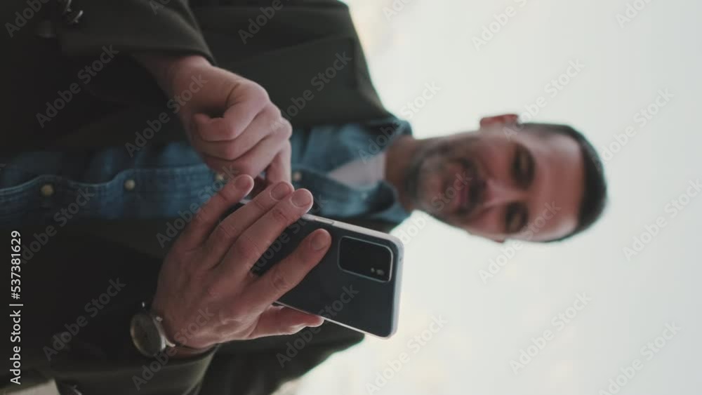 VERTICAL VIDEO: Close-up of man's hands using mobile phone VERTICAL VIDEO: Close-up of man's hands using mobile phone
