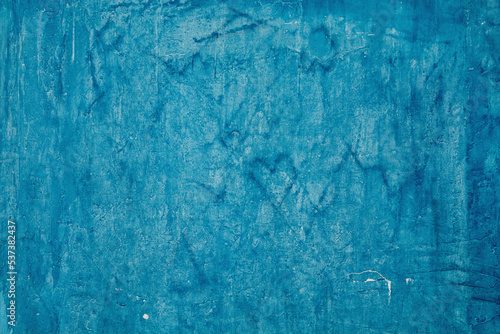 Grunge beautiful bright blue plaster wall with space for text or image. Abstract drawings of heart, lines and cracks on the background. The art of rough stylized texture.