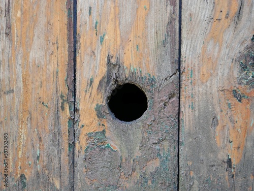 a round hole in a plank of an old door, background