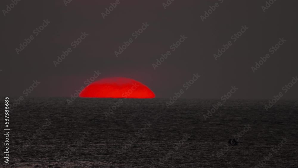 Red sun in the sea, picturesque sunset. Evening landscape on the coast Red sun in the sea, picturesque sunset. Evening landscape on the coast