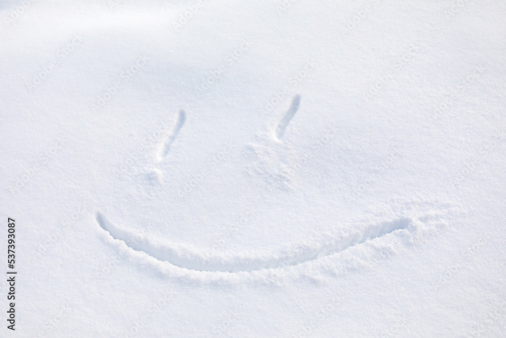 Joyful smile. Symbolic drawing of contented face with smile in snow. Concept of holidays, winter activities