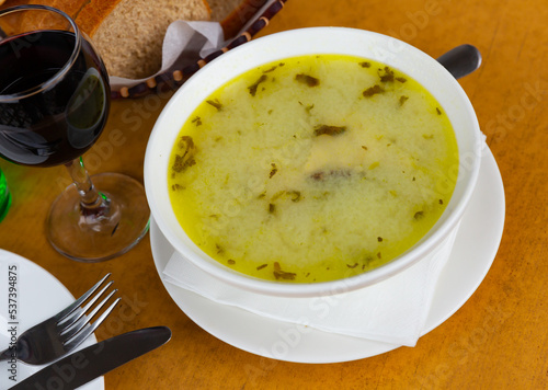 Traditional Georgian soup Chikhirtma from chicken and broth thickened with beaten eggs and flour served in white plate photo