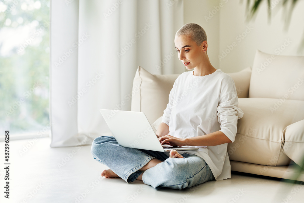 Beautiful woman freelancer with very short hair working at laptop at home Beautiful woman freelancer with very short hair working at laptop at home