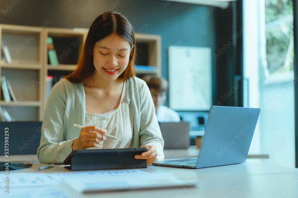 Beautiful young Asian businesswoman working at workspace.