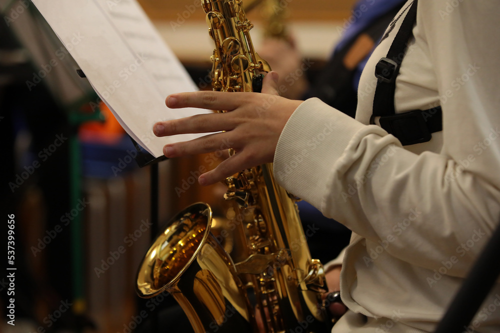 Obraz premium The person playing the saxophone fingers on the valve