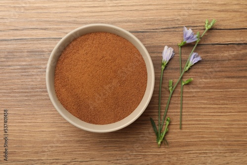 Bowl of chicory powder and flowers on wooden table  flat lay