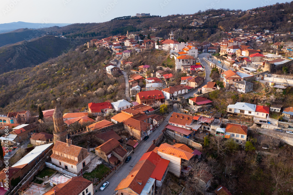 Aerial view of residential areas of small mountainous town of Sighnaghi on hillside in springtime, Kakheti region, Georgia