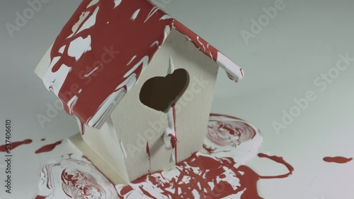 Red and White Paint Pours Onto Wooden Birdhouse 4K photo